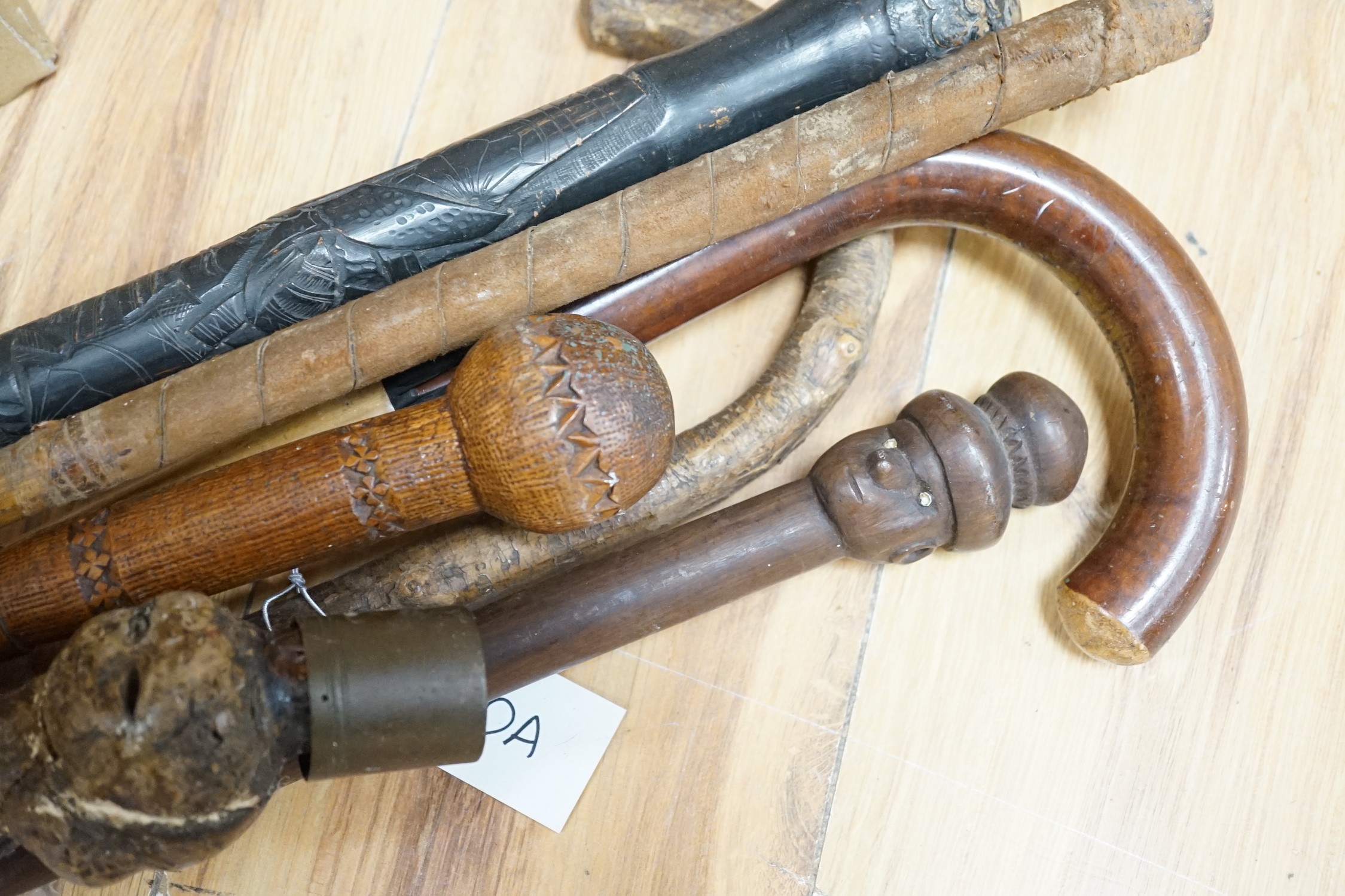 An early 20th century umbrella walking stick, five others and a golf club
